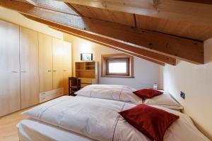 a bedroom with two beds and wooden ceilings at Hotel San Rocco in Livigno