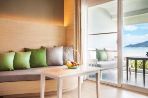 a living room with a couch and a table at Amari Phuket in Patong Beach