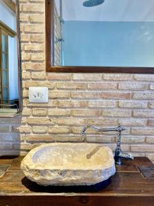 ein Badezimmer mit einem Steinwaschbecken an einer Ziegelwand in der Unterkunft Origens II - Ideal para parejas in Perelló