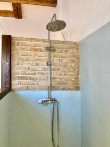 eine Dusche im Bad mit Ziegelwand in der Unterkunft Origens II - Ideal para parejas in Perelló