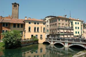 eine Brücke über einen Fluss in einer Stadt mit Gebäuden in der Unterkunft Holiday Treviso Suite Venezia in Treviso