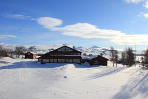 a cabin in the snow with mountains in the background at Høvringen Høgfjellshotell in Høvringen