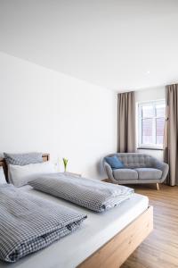 sypialnia z 2 łóżkami i niebieską kanapą w obiekcie Kaneder Hof - Self Check-in w mieście Inchenhofen