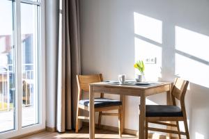 stół i krzesła w pokoju z oknem w obiekcie Kaneder Hof - Self Check-in w mieście Inchenhofen