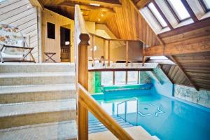 an indoor pool in a house with wooden ceilings and stairs at Pokoje Krupówki 13 - Hotel Sabała in Zakopane