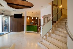 un salon avec des escaliers et une télévision dans l'établissement Hotel Rincón del Conde, à León