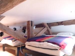 Ce lit se trouve dans un dortoir doté d'un plafond en bois. dans l'établissement La petite maison CARRÉ, à Talant