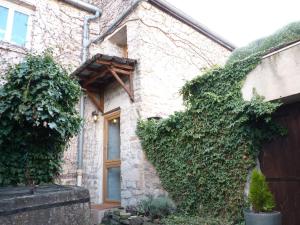 una casa ricoperta di edera con una porta e un edificio di La petite maison CARRÉ a Talant