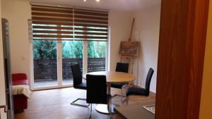 a living room with a table and chairs and a window at Landhaus Bukenberger in Freudenstadt