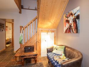 a living room with a couch and a staircase at Bogindour Cottage in Muir of Ord