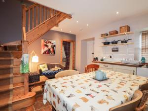 a kitchen and dining room with a table and a staircase at Bogindour Cottage in Muir of Ord
