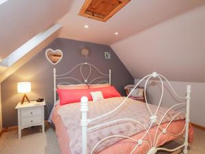 a bedroom with a bed with a white bed frame at Bogindour Cottage in Muir of Ord