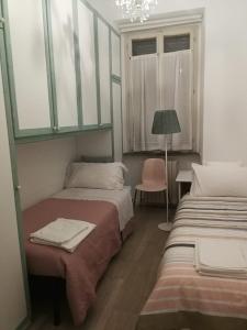 een kamer met 2 bedden en een lamp en een stoel bij Central 2 bedrooms 2 bathrooms in Ancona