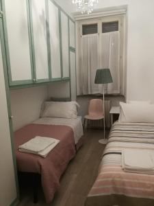 Zimmer mit 2 Betten, einer Lampe und einem Stuhl in der Unterkunft Central 2 bedrooms 2 bathrooms in Ancona