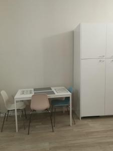 eine Küche mit einem Tisch und Stühlen sowie einem Kühlschrank in der Unterkunft Central 2 bedrooms 2 bathrooms in Ancona