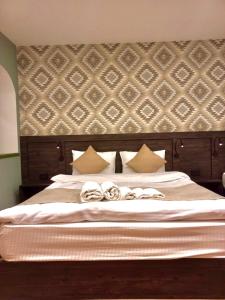 a bedroom with a large white bed with a wall at Old Town Mtatsminda in Tbilisi City