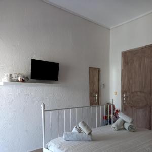 a bedroom with a bed with a tv on the wall at WHITE STUDIOS in Himare