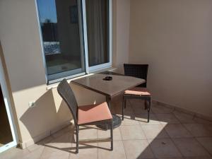
a chair and table in a room with a window at Riva1 Apartments and Rooms in Prizba
