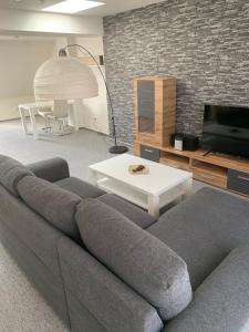 un soggiorno con divano grigio e tavolo di Apartmány Mariánská a Česká Lípa