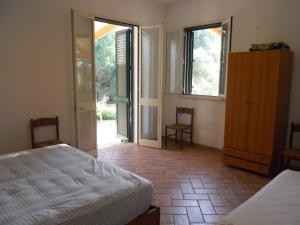 1 dormitorio con 1 cama y puerta que da a un patio en Agriturismo Specchiarussa, en Morciano di Leuca