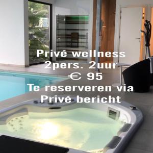 a jacuzzi tub in a house with the words prize wellness opens at B&B Vita Roka met extra Luxe Privé Wellness in Ursel