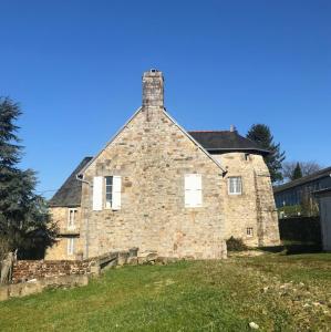 ein altes Steinhaus mit Kamin oben in der Unterkunft La tour cachée in Mortain