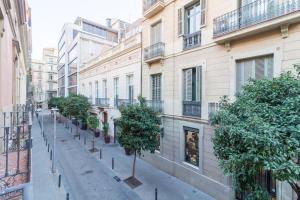 una strada con alberi ed edifici in una città di Key Paseo de Gracia Gaudí y Miró a Barcellona