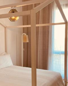 a bedroom with a canopy bed with a window at Casa d'Autore in Ostuni