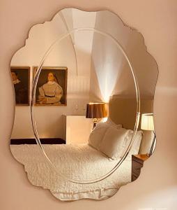 a bedroom with a circular mirror on the wall at Casa d'Autore in Ostuni