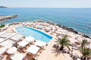 - une vue aérienne sur un complexe avec une piscine et l'océan dans l'établissement Grupotel Aguait Resort & Spa - Adults Only, à Cala Ratjada