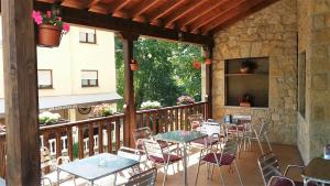 a patio with tables and chairs on a balcony at Hotel Rural Cabrales in Carreña de Cabrales