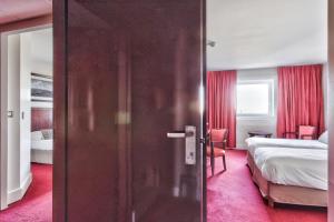 - une porte dans une pièce avec un lit et une chambre dans l'établissement Golden Tulip Paris CDG Airport – Villepinte, à Roissy-en-France