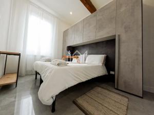 sypialnia z dużym łóżkiem z betonową ścianą w obiekcie Gold River House w mieście Ferrara
