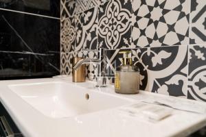 - białą umywalkę w łazience wyłożonej czarno-białymi kafelkami w obiekcie Gold River House w mieście Ferrara +19 zdjęć