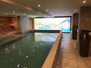 a swimming pool with a large screen in a building at Hotel La Toviere in Val dʼIsère