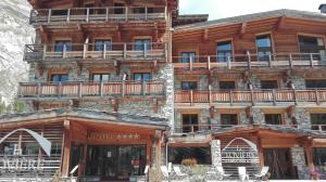 a large wooden building with balconies on it at Hotel La Toviere in Val dʼIsère
