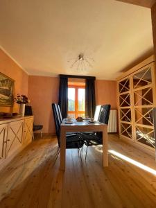 d'une salle à manger avec une table, des chaises et une fenêtre. dans l'établissement Suite - La Casa del Maestro, à Pragelato