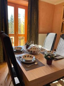 - une table en bois avec des assiettes et des verres à vin dans l'établissement Suite - La Casa del Maestro, à Pragelato