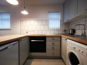a kitchen with a sink and a dishwasher at Surfer's Retreat in Chichester