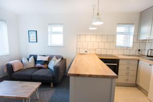 a kitchen and living room with a couch and a table at Surfer's Retreat in Chichester