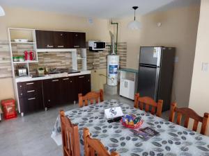 a kitchen with a table and a refrigerator at LOS CEDROS in Junín de los Andes