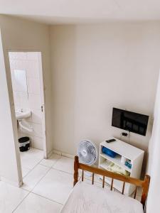 a small room with a television and a chair at Pousada alojacampinas in Viracopos