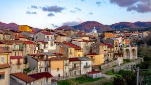 un gruppo di edifici con montagne sullo sfondo di Bed and Breakfast Il Sole -Cinquefrondi a Cinquefrondi