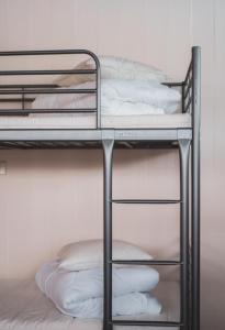 two bunk beds in a room with white pillows at NorthEast Guesthouse in Bakkafjörður