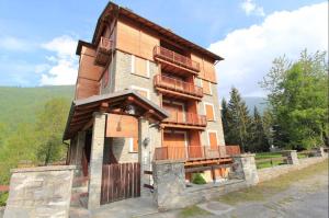 una grande casa in legno con una recinzione di fronte ad essa di Suite - La Casa del Maestro a Pragelato