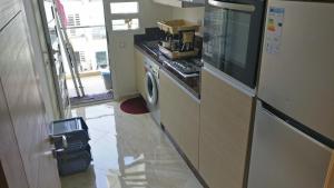 a kitchen with a stove and a washer and dryer at Casabay Appart Vue Sur Piscine in Sidi Rahal