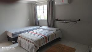 Un dormitorio pequeño con dos camas y una ventana. en Flat Santa Maria, en Fortaleza