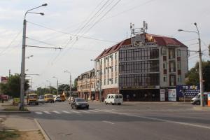 a street with cars driving down a street with a building at Petrovsk Hotel in Makhachkala