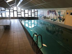 a swimming pool in a building with a pool at Appartment SIMONE mit Seeblick in Steindorf am Ossiacher See