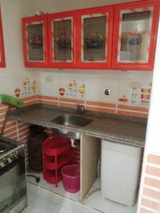 a kitchen with red cabinets and a sink at Villa Teba - Marouf Group in Ras El Bar